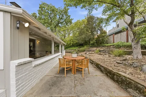 a view of a patio with a table and chairs next to a yard