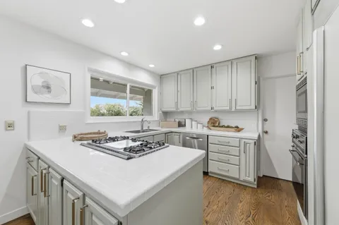a kitchen with a stove a sink and a refrigerator