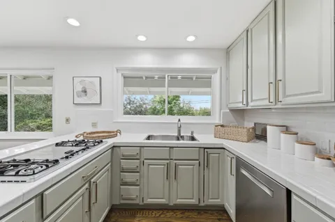 a kitchen with a sink stove top oven and cabinets