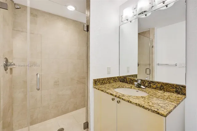 a bathroom with a glass shower door and a window