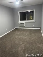 a view of an empty room with a fireplace and wooden floor