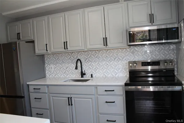 a kitchen with appliances a sink and cabinets