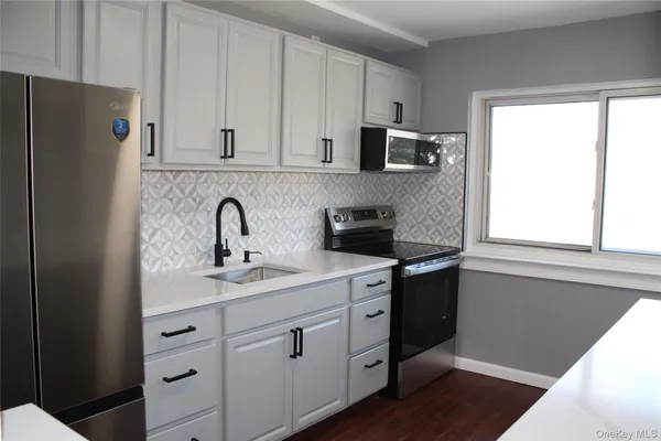 a kitchen with stainless steel appliances white cabinets and a refrigerator