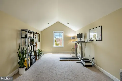 a room with gym equipment and wooden floor