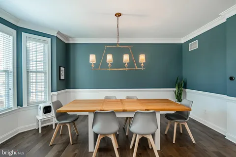 a kitchen with stainless steel appliances granite countertop a dining table chairs stove a refrigerator and cabinets