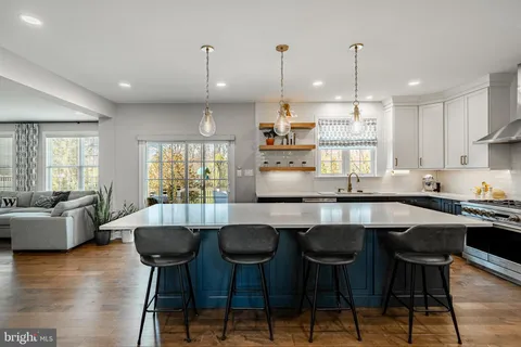 a kitchen with stainless steel appliances a sink a stove and a chandelier