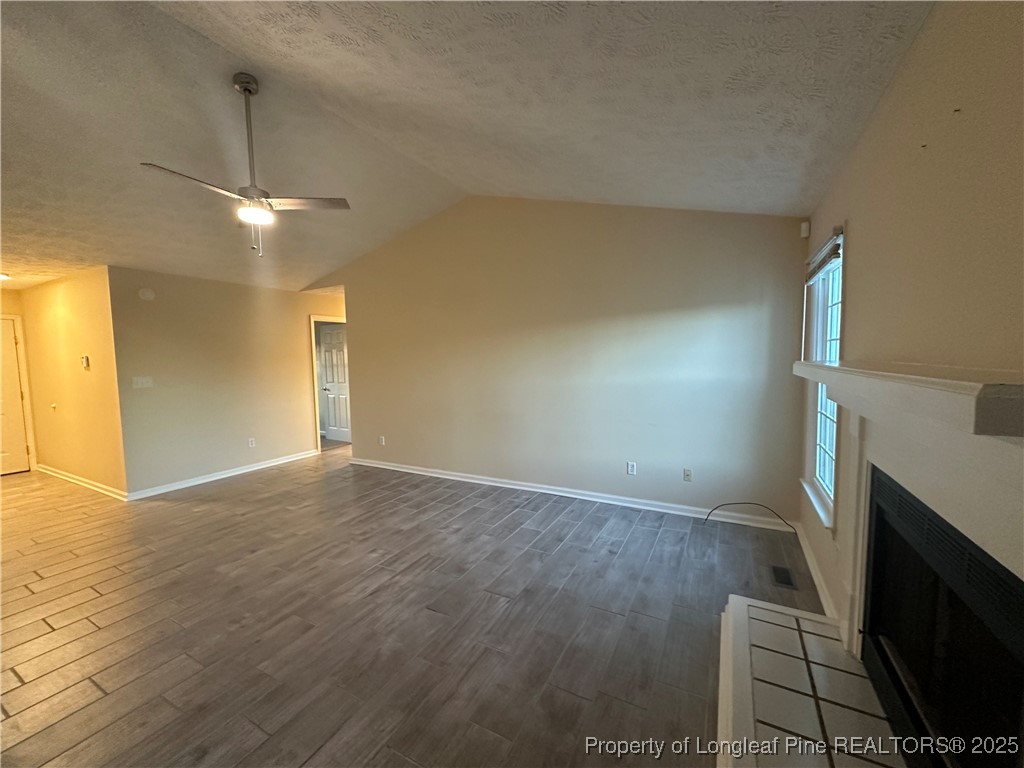 8249 Rockfish Road Raeford, NC 28376 - Photo 3 of 12 a view of empty room with wooden floor and fireplace