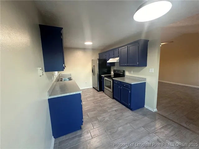 a kitchen with stainless steel appliances granite countertop a sink stove and wooden cabinets