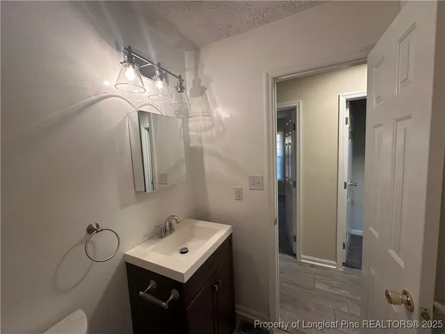 a bathroom with a sink a light fixture and a mirror