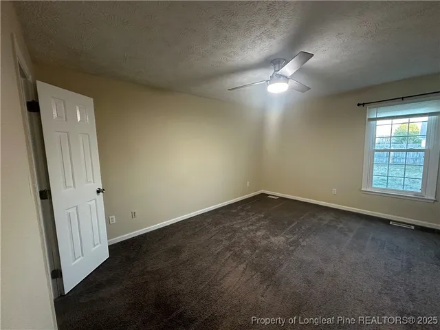 en empty room with windows and fan