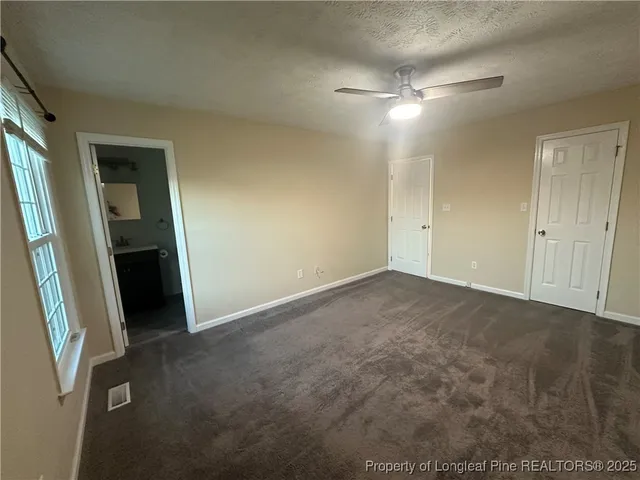 an empty room with closet and mirror