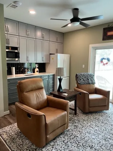 a living room with furniture and a ceiling fan
