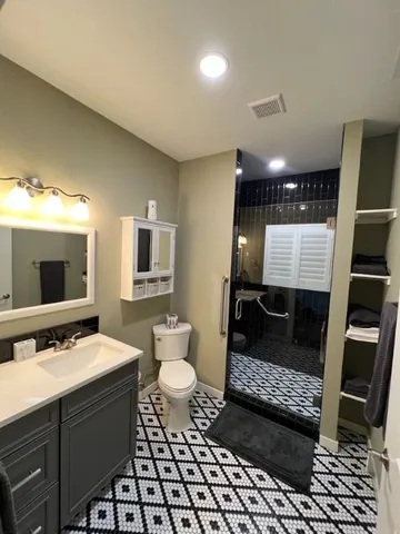 a bathroom with a sink toilet a mirror and shower