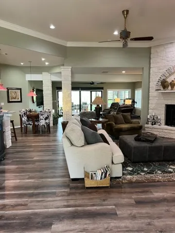 a living room with furniture kitchen view and a wooden floor