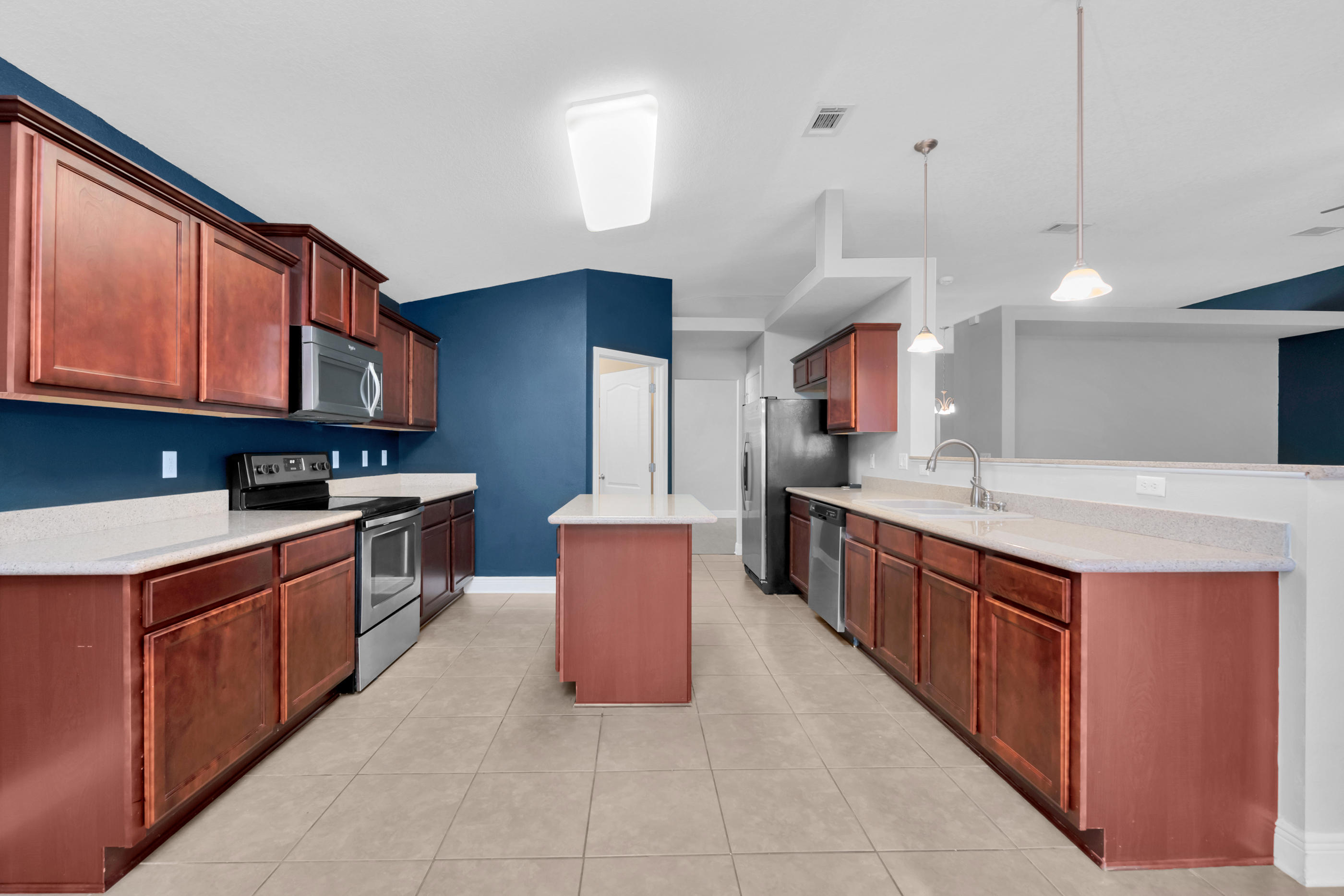 4583 Hermosa Road Crestview, FL 32539 - Photo 11 of 24 a large kitchen with stainless steel appliances kitchen island granite countertop a stove a sink dishwasher and a refrigerator
