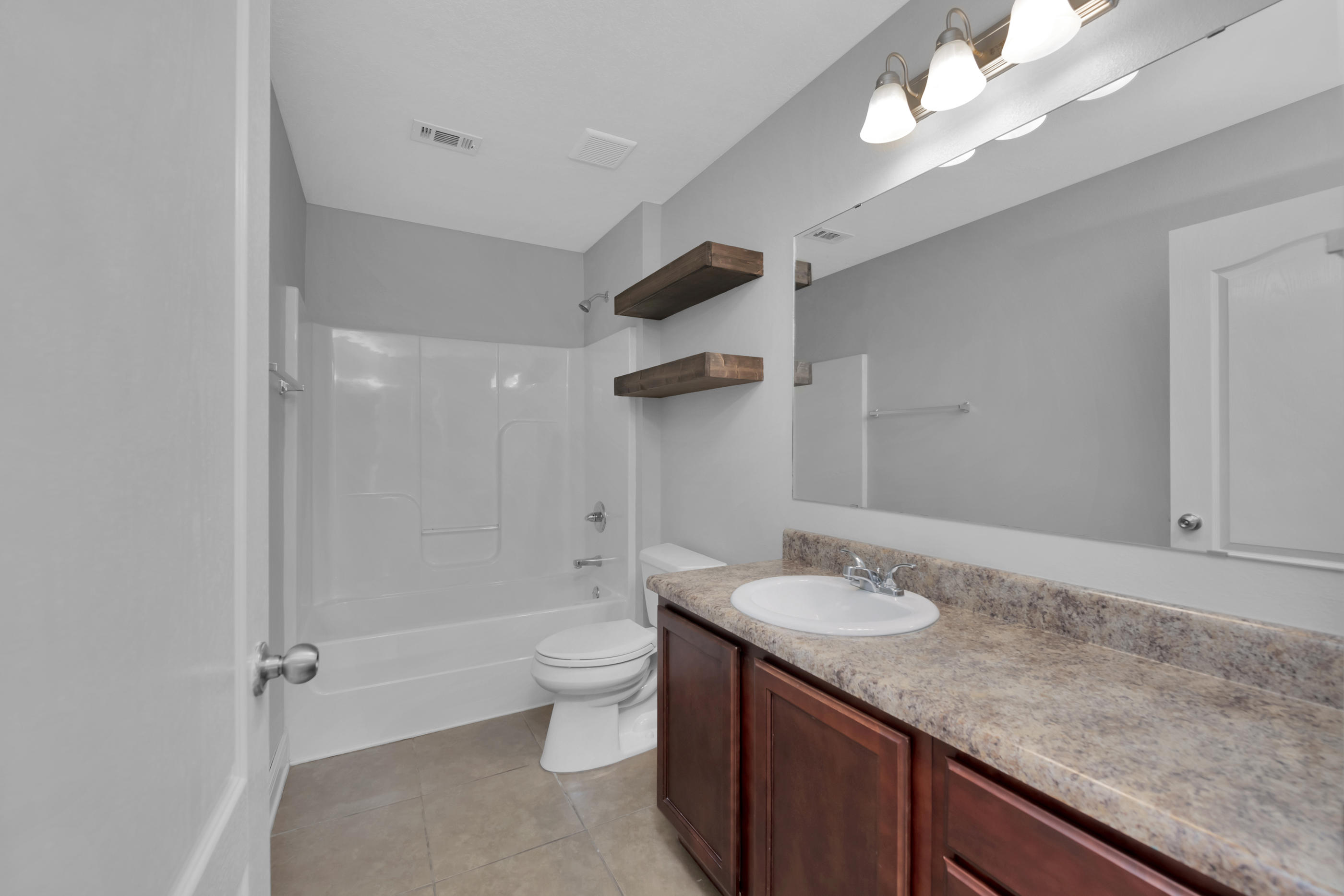 4583 Hermosa Road Crestview, FL 32539 - Photo 22 of 24 a bathroom with a granite countertop sink a toilet and shower
