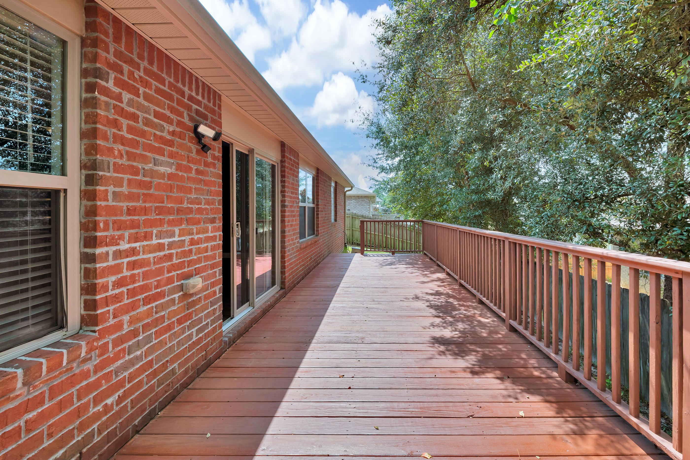 4583 Hermosa Road Crestview, FL 32539 - Photo 23 of 24 a view of a brick house with wooden floor and fence
