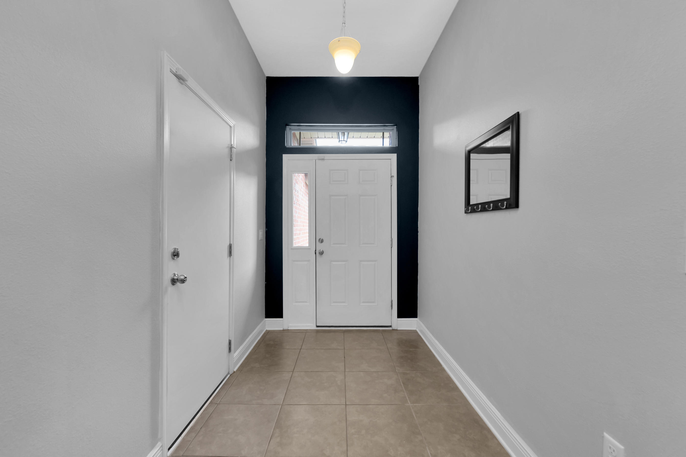 4583 Hermosa Road Crestview, FL 32539 - Photo 4 of 24 a view of a hallway with wooden floor and a bathroom