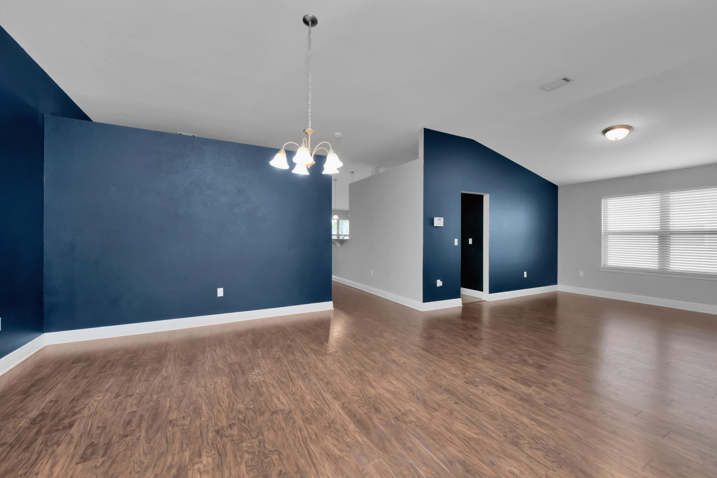 4583 Hermosa Road Crestview, FL 32539 - Photo 6 of 24 a view of an empty room with window and wooden floor