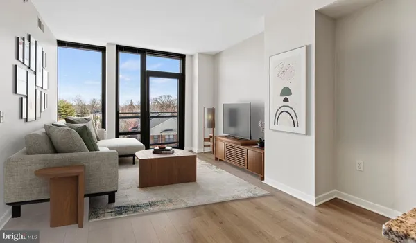 a living room with furniture and a floor to ceiling window