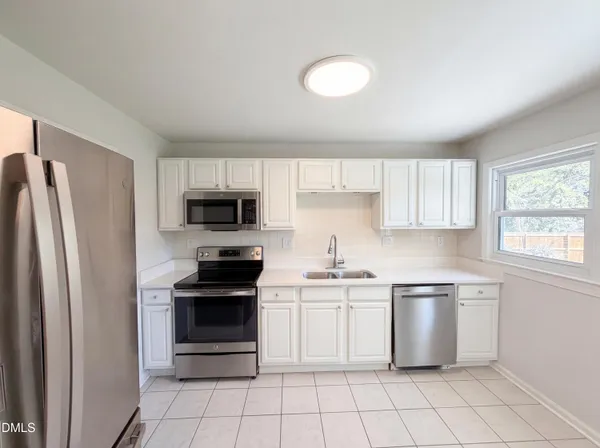 a kitchen with white cabinets and stainless steel appliances