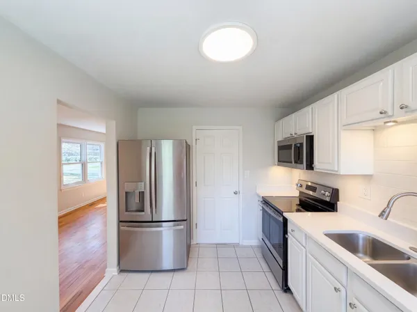 a kitchen with a refrigerator a sink a stove and cabinets