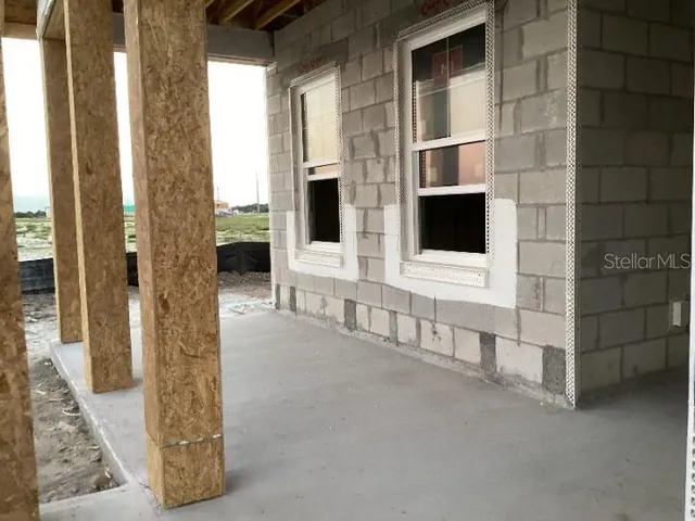a view of a hallway with wooden floor and windows