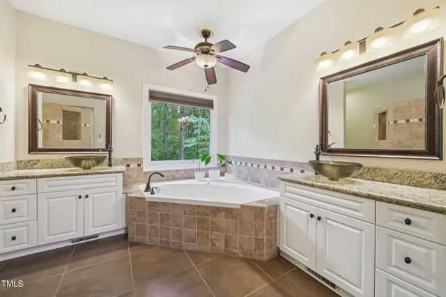 a spacious bathroom with a double vanity sink large mirror and a bathtub