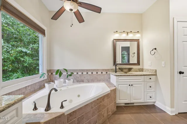 a bathroom with a tub sink and mirror