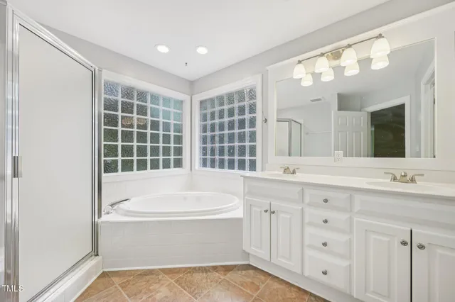 a bathroom with a tub sink and mirror