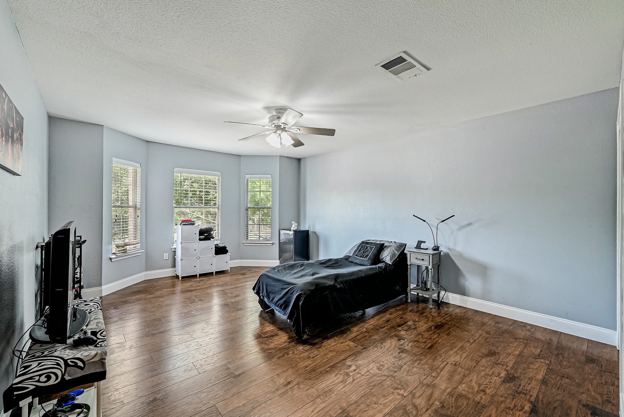 104 North Sumac Lane Georgetown, TX 78633 - Photo 34 of 40 Well-lit sleeping quarters with rich hardwood flooring and multiple window views.