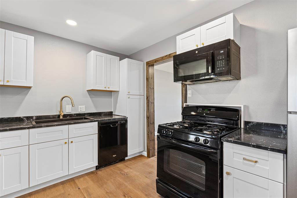 902 Turner Street Cleburne, TX 76033 - Photo 17 of 33 a kitchen with stainless steel appliances granite countertop a stove a microwave and a sink