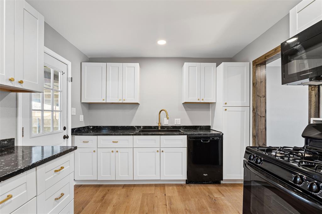 902 Turner Street Cleburne, TX 76033 - Photo 18 of 33 a kitchen with granite countertop a stove sink and cabinets