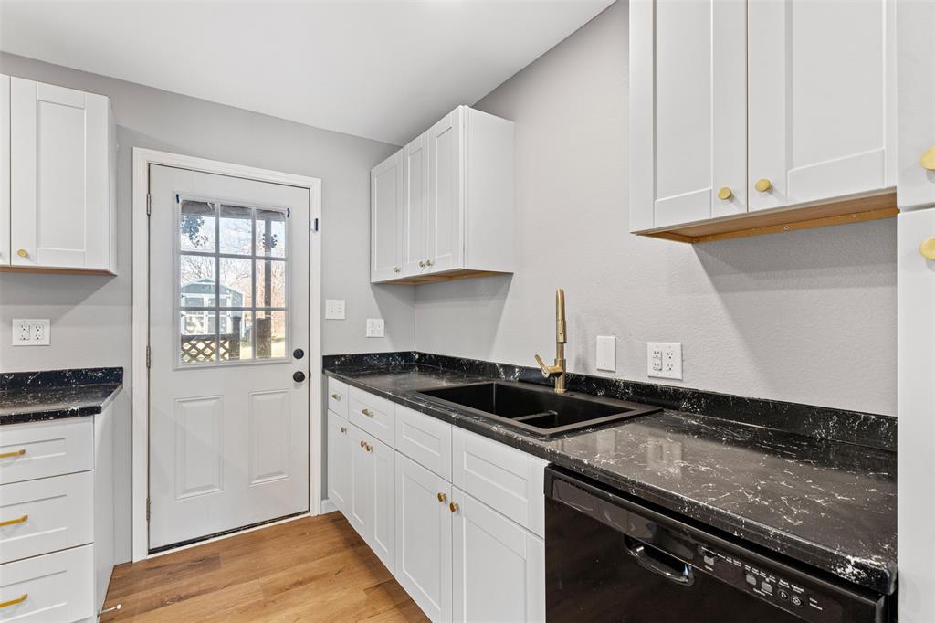 902 Turner Street Cleburne, TX 76033 - Photo 19 of 33 a kitchen with granite countertop white cabinets and a stove top oven