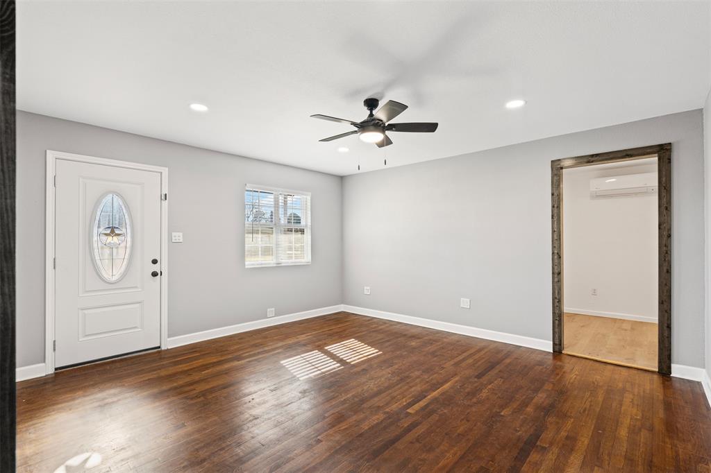 902 Turner Street Cleburne, TX 76033 - Photo 9 of 33 wooden floor in an empty room with a window
