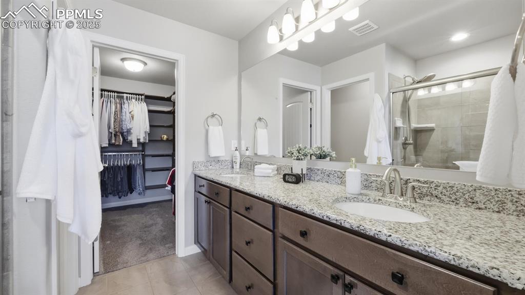 4456 Hessite Loop Colorado Springs, CO 80938 - Photo 22 of 42 a bathroom with a granite countertop double vanity sink and a mirror