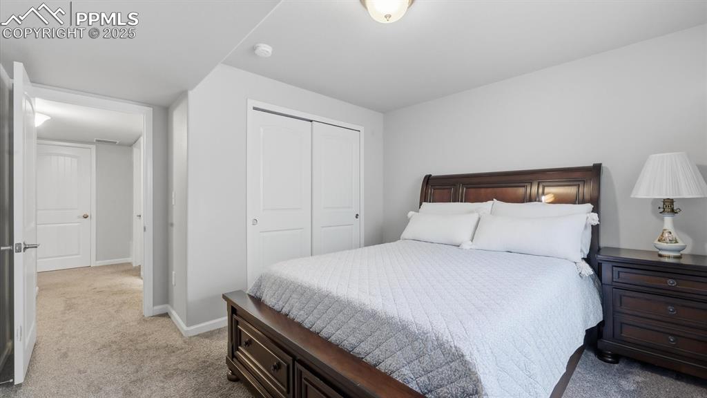 4456 Hessite Loop Colorado Springs, CO 80938 - Photo 34 of 42 a bedroom with a bed and a night stand