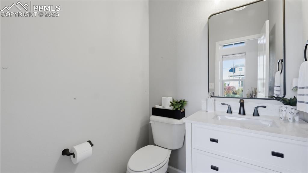 4456 Hessite Loop Colorado Springs, CO 80938 - Photo 8 of 42 a bathroom with a toilet sink vanity and mirror