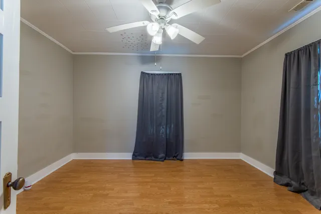 an empty room with a ceiling fan and a window