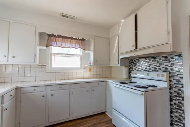 a kitchen with granite countertop white cabinets and white appliances