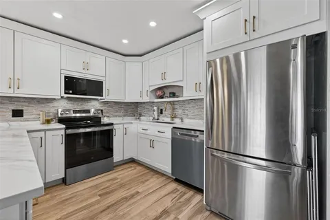 a kitchen with stainless steel appliances a refrigerator stove and microwave