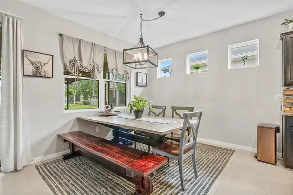 a dining room with wooden floor a chandelier a wooden table and chairs