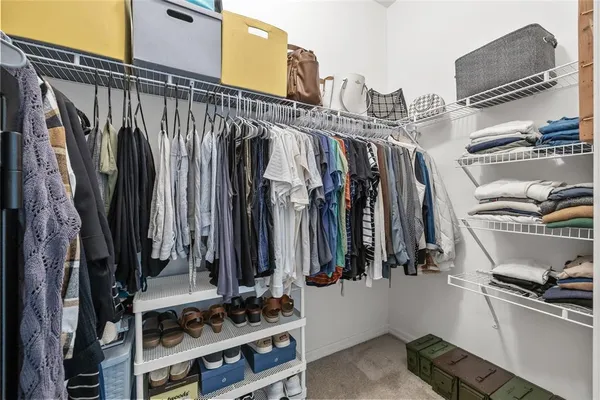 a view of walk in closet with clothes and shoes