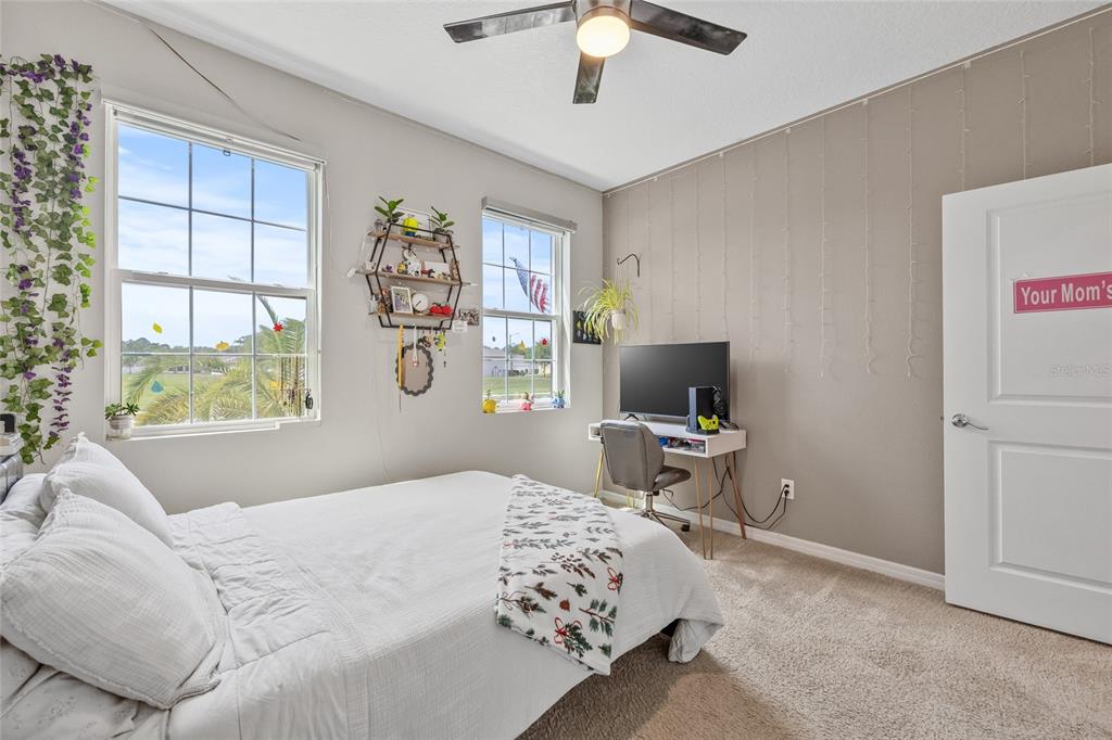 13675 Paddington Way Spring Hill, FL 34609 - Photo 21 of 36 a bedroom with a bed and a flat tv screen on the dresser