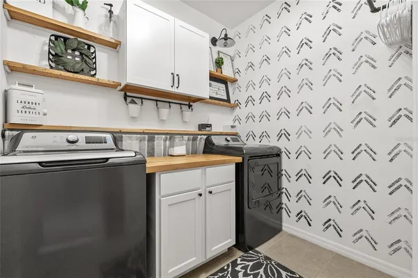 a utility room with stainless steel appliances washer and dryer