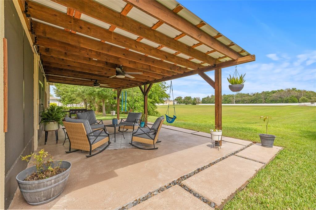13675 Paddington Way Spring Hill, FL 34609 - Photo 29 of 36 a view of a patio with a table chairs and a swimming pool