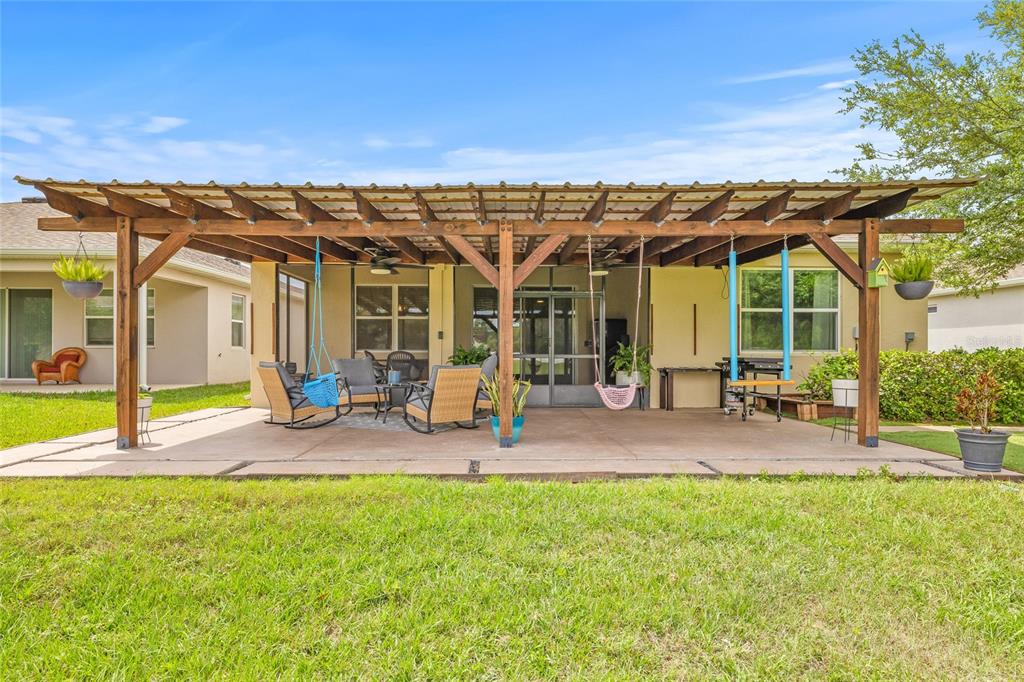 13675 Paddington Way Spring Hill, FL 34609 - Photo 30 of 36 a view of a patio with table and chairs under an umbrella