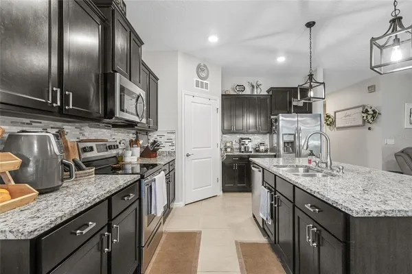 a kitchen with stainless steel appliances granite countertop a sink a stove and a refrigerator