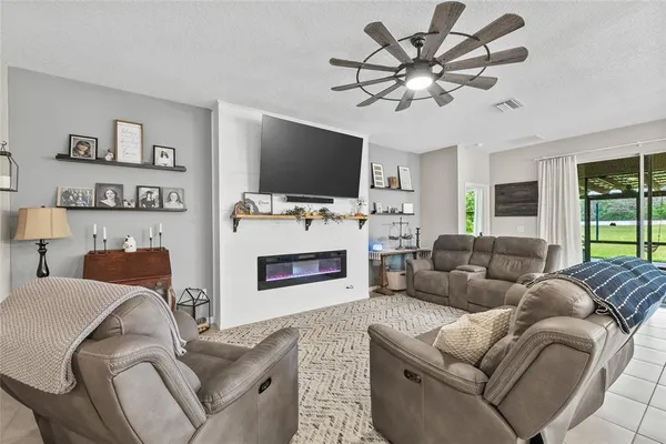 a living room with furniture a flat screen tv and a fireplace
