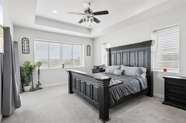 a bedroom with a bed chandelier and a window